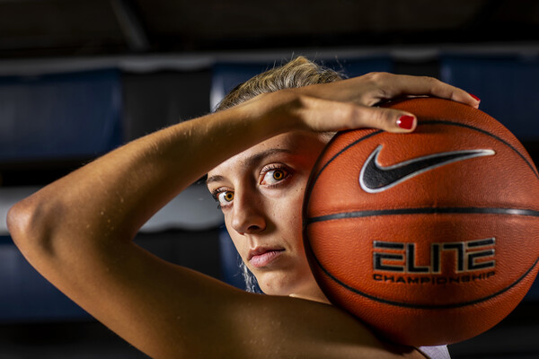 At the Palestra, Kendall Grasela of the women's basketball team poses with a ball resting on her shoulder.