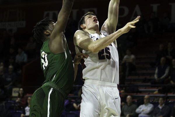 Senior forward A.J. Brodeur lays the ball up against Dartmouth at the Palestra while a defender tries to block his shot.