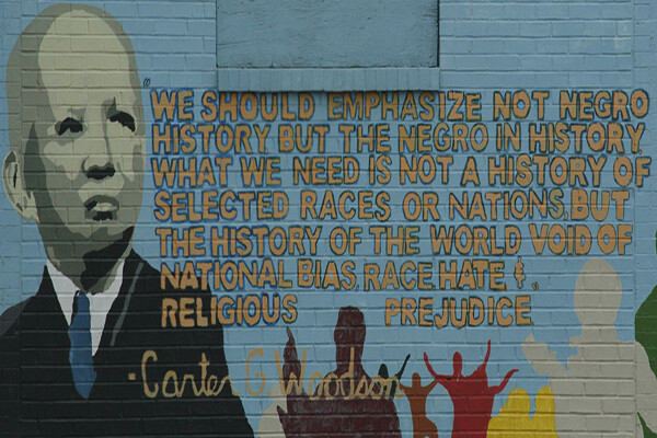 Mural of Carter G. Woodson on a brick wall with a quote reading "We should emphasize not Negro history but the Negro in history. What we need is not a history of selected races or nations, but the history of the world void of national bias, race, hate and religious prejudice."