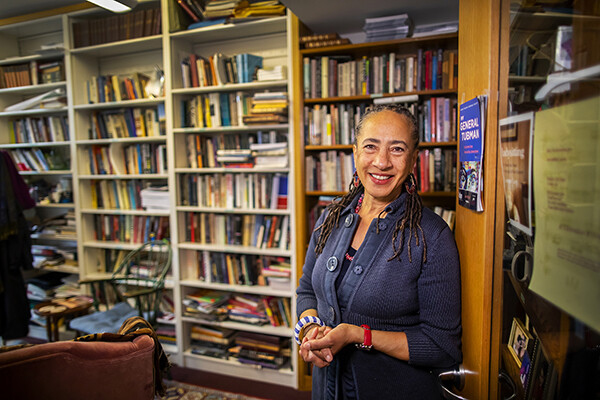 Lorene Cary stands in her office with a wall of bookshelves behind her