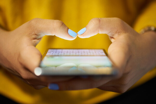 Hands holding smartphone with fingers poised over screen