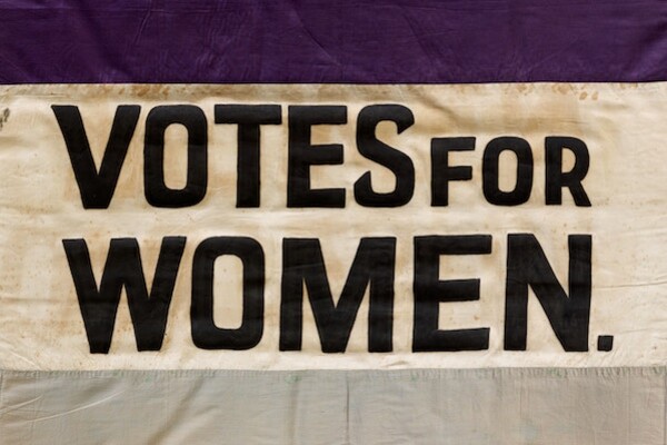 a flag with three horizontal stripes with the words Votes for Women in the center