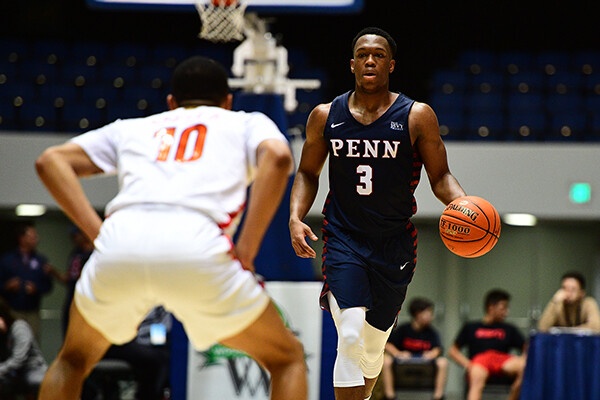 Jordan Dingle dribbles the basketball down the court during a Penn basketball game.