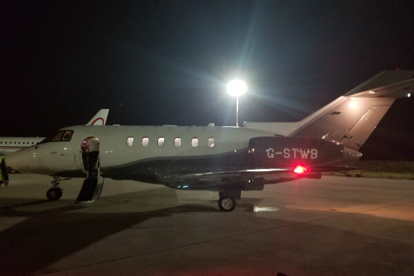 small plane sits on tarmac with cabin door open and stairs dropped.