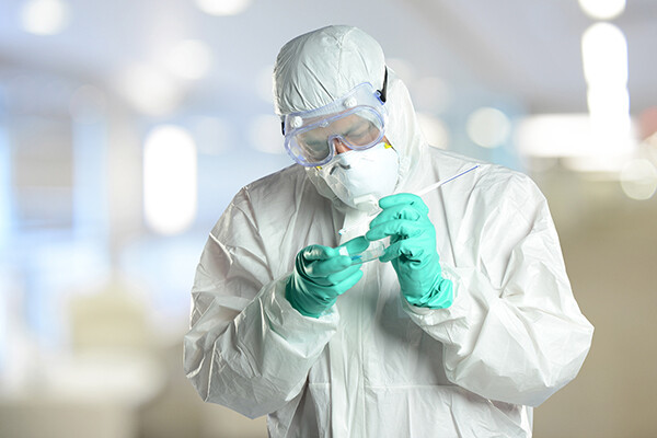Scientist in protective hazmat suit working in laboratory.