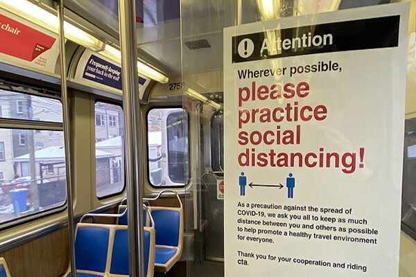 Sign on the wall inside an empty public transit trolley that reads Please practice social distancing.