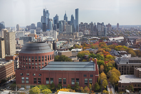 Aerial view of Wharton building on Penn campus with skyline of the city behind it