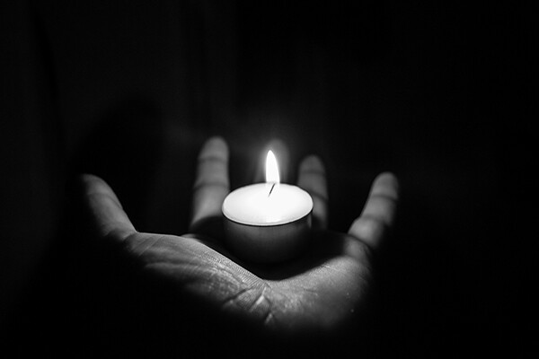 Open palm holding a small candle