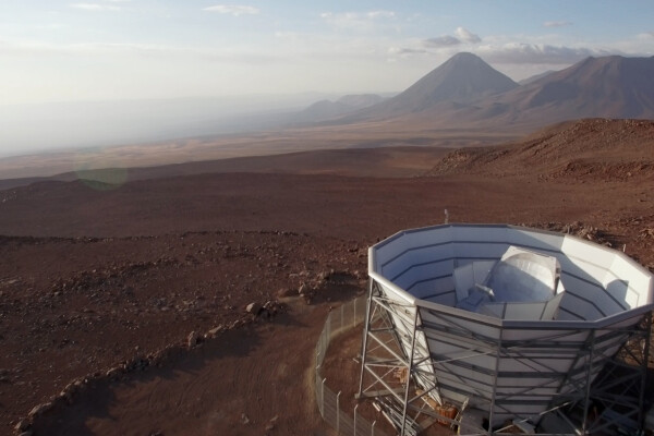 the Atacama Cosmology Telescope in the foreground and the desert and mountains of chile in the background