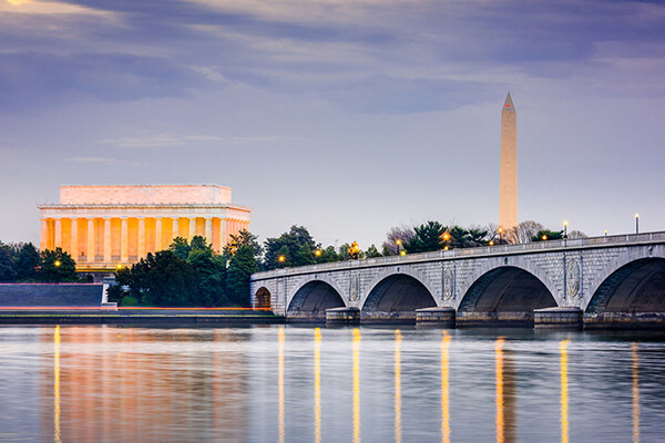 Lincoln Memorial illuminated at dusk overlooking the Potomac River.