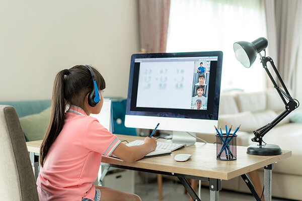 Young elementary school student at a home computer attending virtual school.