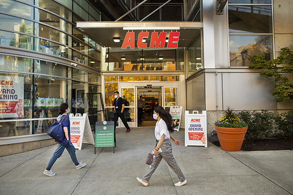 people walk past the new ACME market