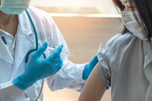 Health care worker prepares to give patient a vaccine injection