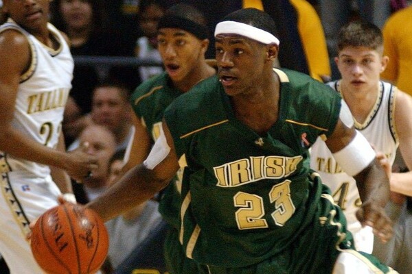 LeBron James dribbles the ball up the court while wearing a green Irish jersey with number 23 while in high school at St. Vincent-St. Mary