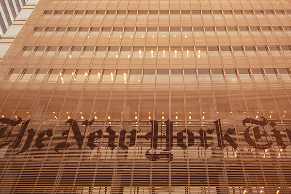 Facade of New York Times building with lettering on the face of the building.
