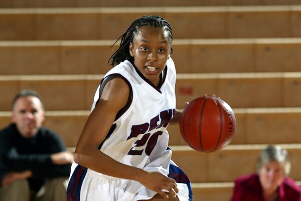 Wearing her white uniform at the Palestra, former forward Jewel Clark dribbles the ball up the court.