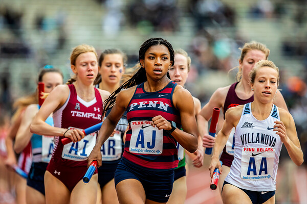Nia Akins leads a pack of runners while running in a relay race at the Penn Relays.