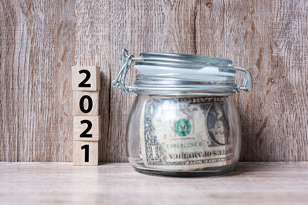 picture of savings jar with money in it and blocks saying 2021