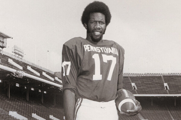 Marty Vaughn standing with a football on Franklin Field in 1974.