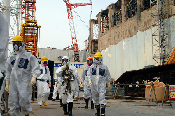 People in hazmat suits walk around the Fukushima nuclear plant in 2013