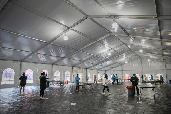 Penn students in a large outdoor tent that is a COVID-testing site.