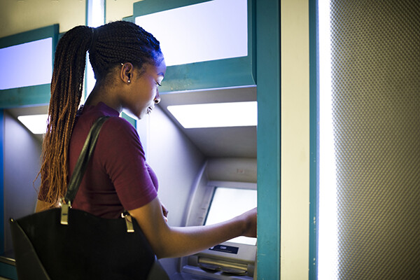 African American woman using an ATM.