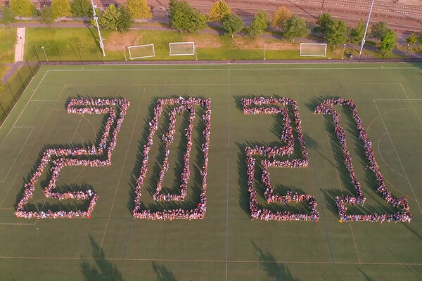 aerial view of people standing on field to spell out 2021