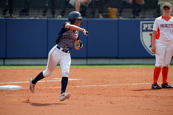 Wearing her blue Penn jersey, Leah Allen pumps her fist while running around the bases.