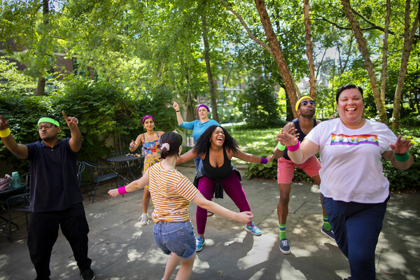 Seven people dancing outside in a Penn courtyard.