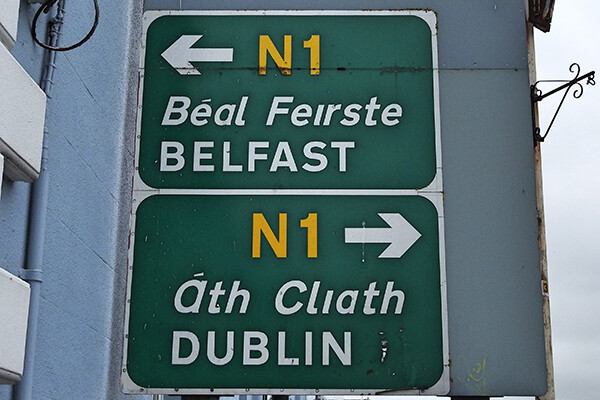 Two green N1 highway signs stacked on top of each other show arrows pointing the way to Belfast in the top sign and the way to Dublin in the bottom sign, with Belfast to the left and Dublin to the right