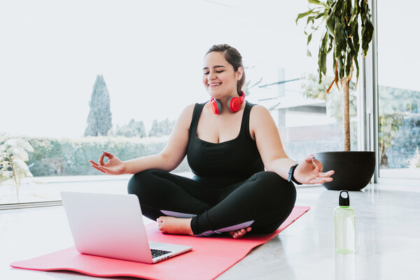 person sittin in front of laptop while meditating