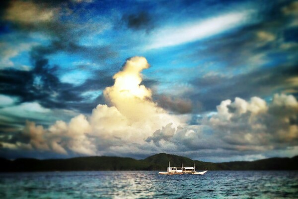 Palawan seascape and boat with clouds in distance