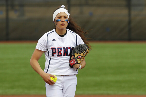 Alexis Borden holds the ball in her left hand in the pitcher's circle as she prepares to throw a pitcher at Penn Park, wearing her white Penn jersey.