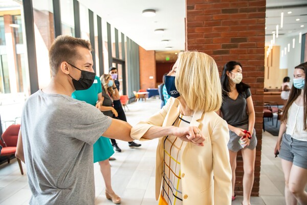 Penn President Amy Gutmann and a student elbow-bump as a greeting