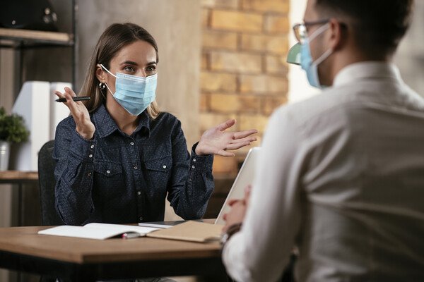 Businesspeople in conversation wearing face masks