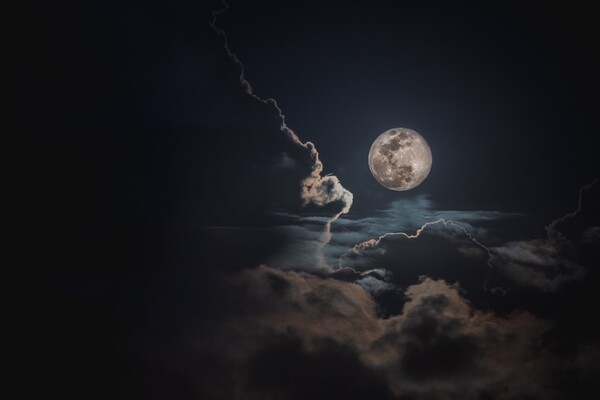 A full moon with clouds in the sky