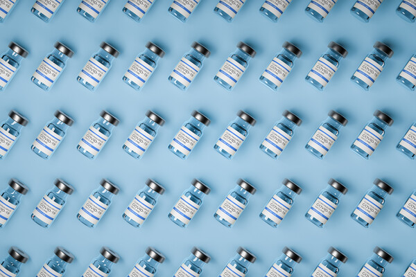 Five rows of COVID-19 vaccine vials. The vials are angled diagonally, from bottom left to top right. 