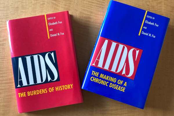 Two hardcover books on a table, “AIDS: The Burden of History” and “AIDS: The Making of a Chronic Disease.”