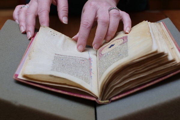 Emily Steiner’s hands hold open an antique book.