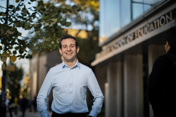 professor standing in front of Graduate School of Education building