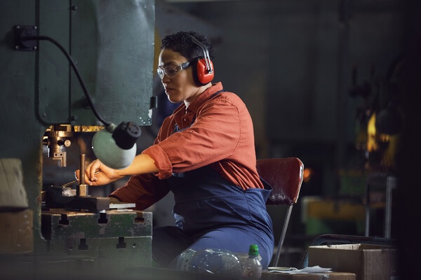 Factory worker seated at a machine.