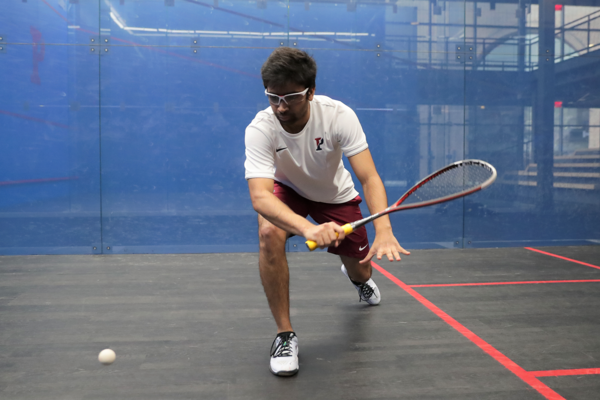 Playing in a glass court at the Penn Squash Center, Yash Bhargava prepares to swing at the ball.