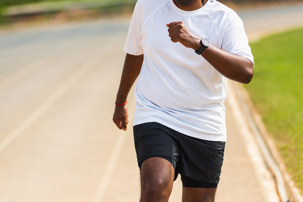 African American man jogging on a track.