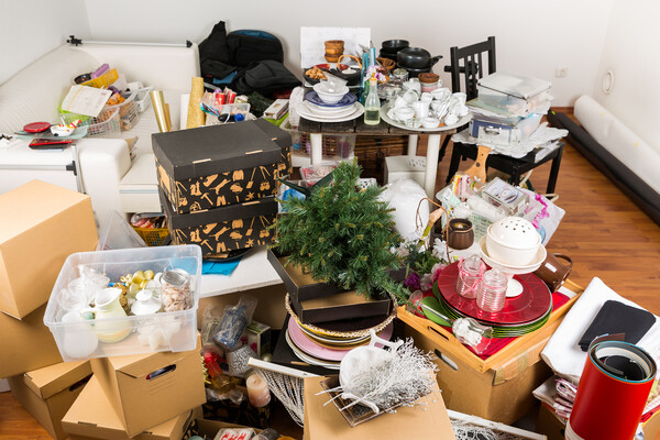 Pile of holiday clutter including decorations and flatware on the floor of a dining room.