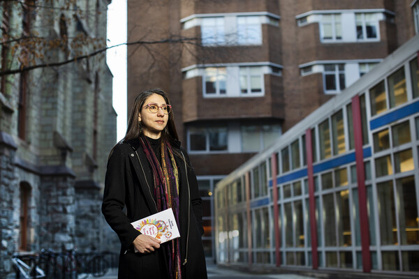 Huda Fakhreddine holding the poetry book outside