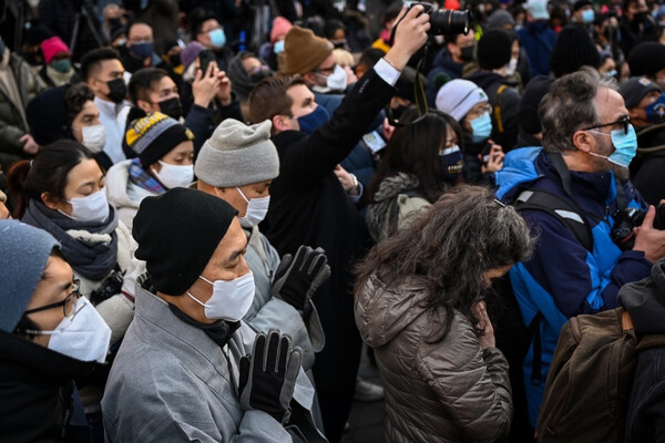 Group of people wearing masks at a vigil in Philadelphia.
