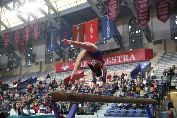 Sydney Kraez performs a back flip on the beam during a meet at the Palestra.