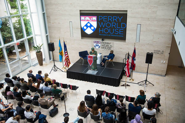 Audience at Perry World House listening to two speakers seated on stage.