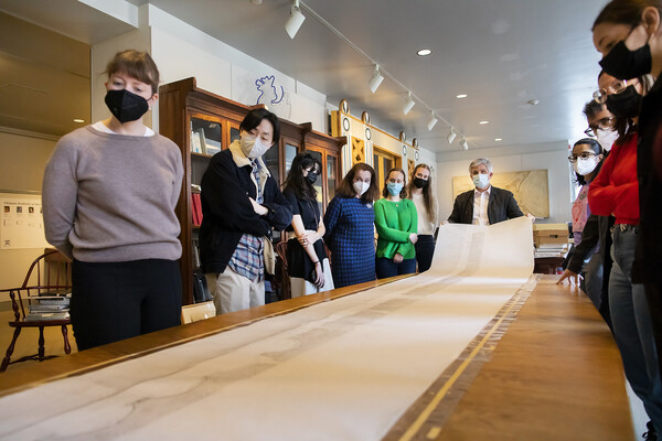 students examine a long scroll in the archive class