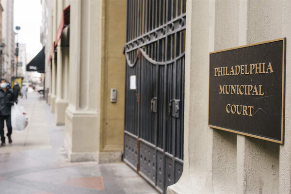 Sidewalk entrance for Philadelphia Municipal Court with plaque at gate.